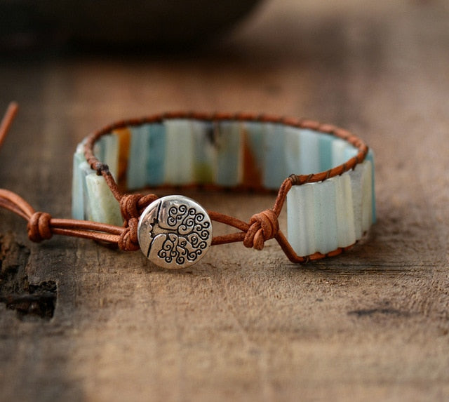Bracelet with ceramic band and metal heart charm on a wooden surface