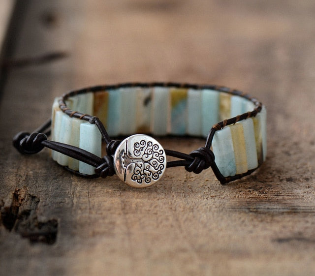 Bracelet with tree of life charm on a wooden surface