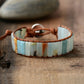 Bracelet with stone beads and leather strap on a wooden surface