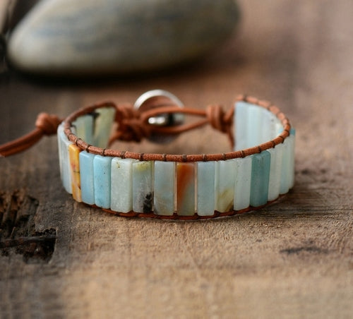 Bracelet with stone beads and leather strap on a wooden surface