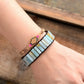 Bracelet with colorful stones on a wrist against a wooden background