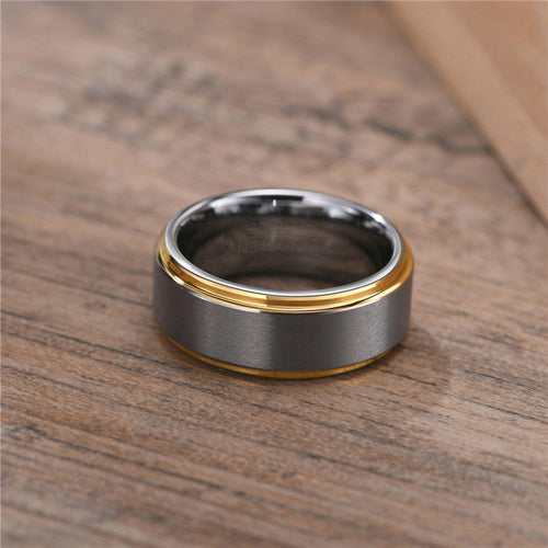 Two-toned ring with gold and black finish on a wooden surface