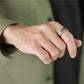 Hand wearing two rings on a blurred background