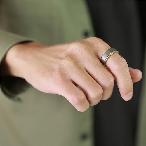 Hand wearing two rings on a blurred background