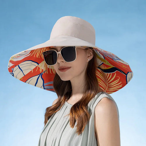 Woman wearing a large sun hat with a colorful brim against a clear blue sky