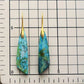 Pair of blue marbled earrings with gold hooks on a grid background