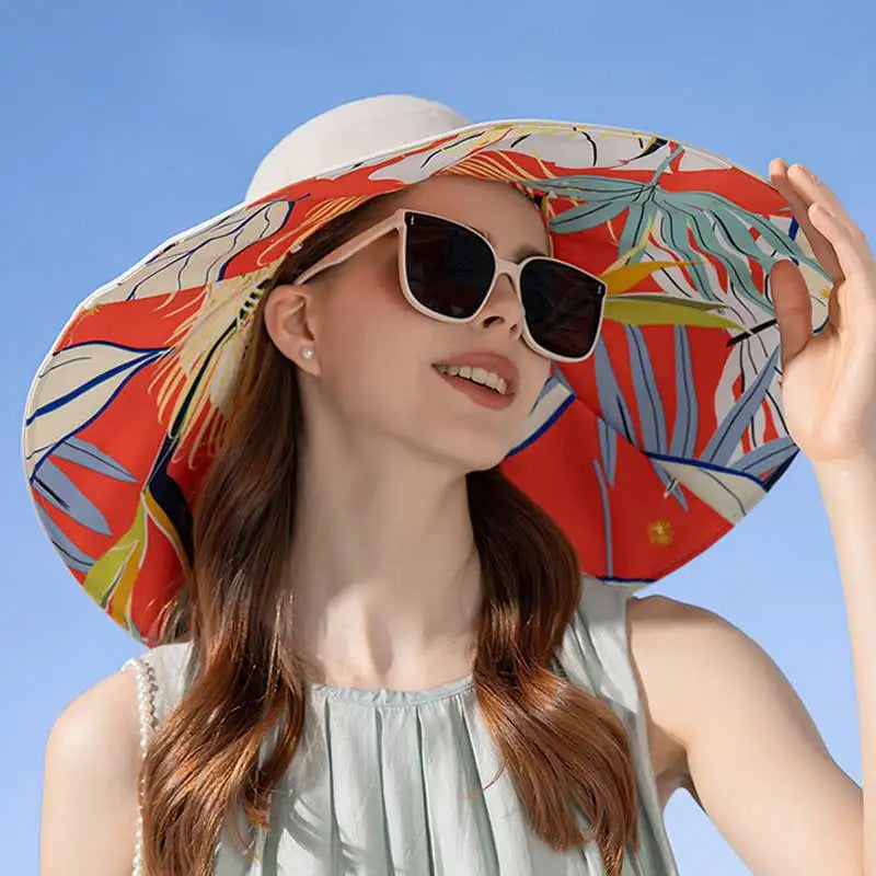 Woman wearing a colorful sun hat and sunglasses against a clear blue sky