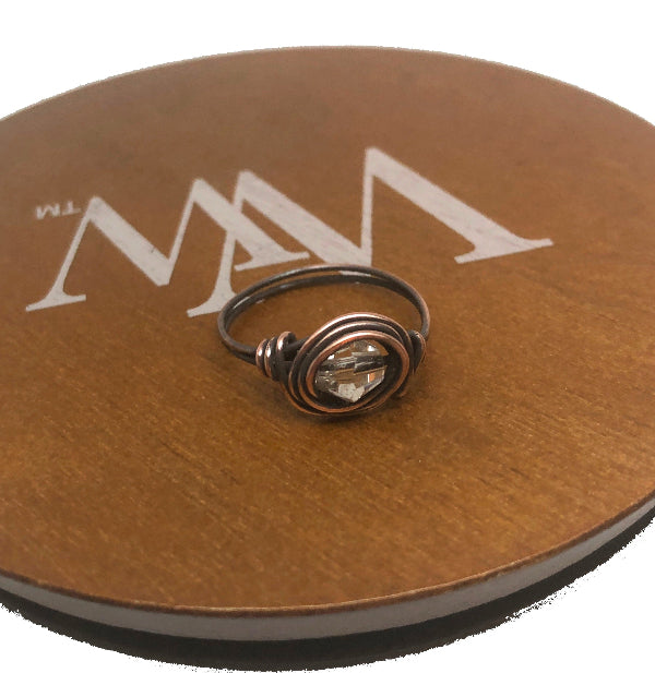 Ring on a brown circular stand with a logo