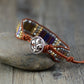 Bracelet with decorative button and colorful beads on a stone surface