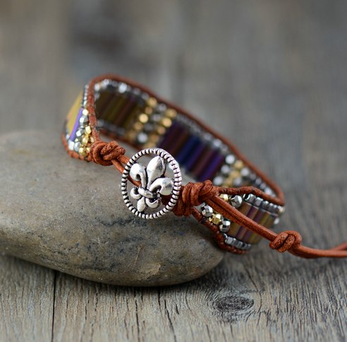 Bracelet with decorative button and colorful beads on a stone surface