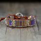 Bracelet with colorful beads and leather strap on a wooden surface