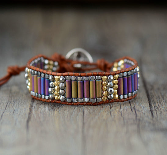 Bracelet with colorful beads and leather strap on a wooden surface