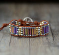 Bracelet with colorful beads and leather strap on a wooden surface