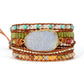 Multicolored beaded bracelet with a large central stone on a white background
