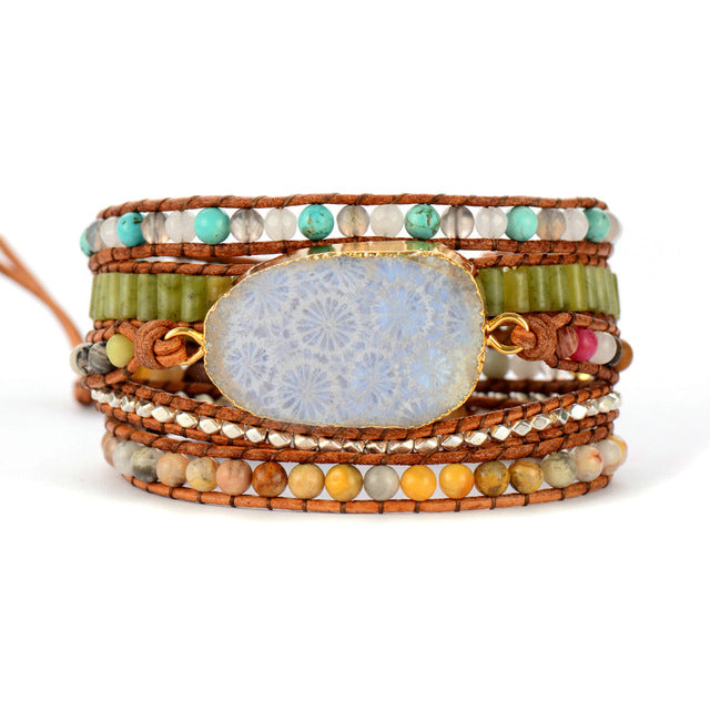Multicolored beaded bracelet with a large central stone on a white background
