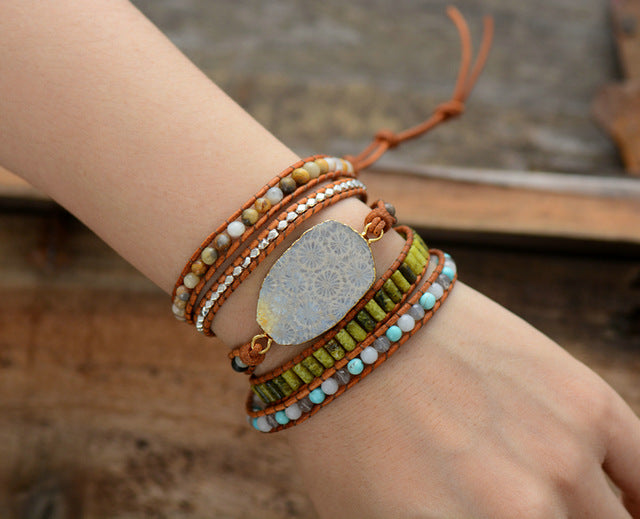 Close-up of a wrist wearing multiple colorful bracelets with a natural stone focal point.