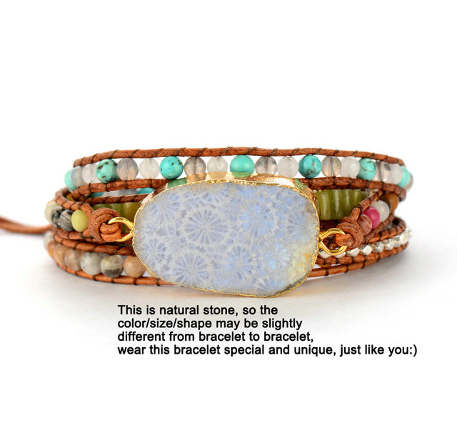 Multistrand beaded bracelet with a large natural stone focal point on a white background.