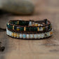 Multistrand beaded bracelet with brown leather wrap on a wooden surface