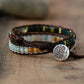 Multistrand beaded bracelet with a tree of life charm on a wooden surface