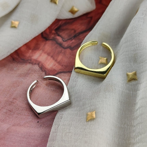 Gold and silver hoop earrings on a textured fabric background