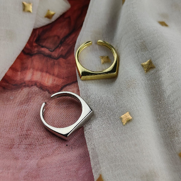 Two gold hoop earrings on a textured fabric background with small decorative elements.