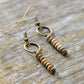 Beaded earrings with bronze hooks on a wooden surface