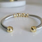 Silver and gold bracelet on a white surface