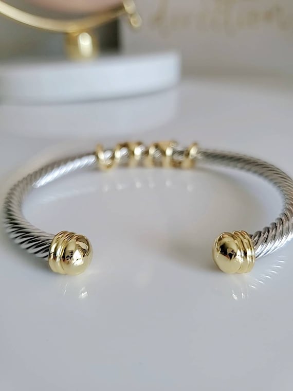 Silver and gold bracelet on a white surface