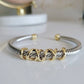 Gold and silver bracelet on a white surface