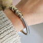 Gold and silver braided bracelet on a wrist with a blurred background
