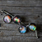 Set of cufflinks with nebula designs on a rustic wooden surface