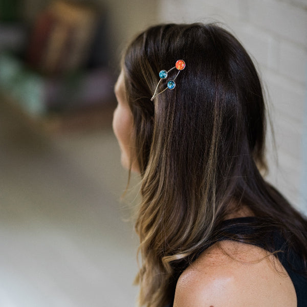 Person with a decorative hairpin in their hair, blurred background