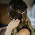 Person adjusting a hair accessory with beads in their hair