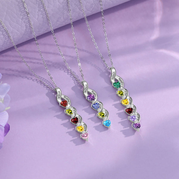 Three silver necklaces with colorful gemstones on a purple background