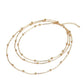Set of three gold necklaces on a white background