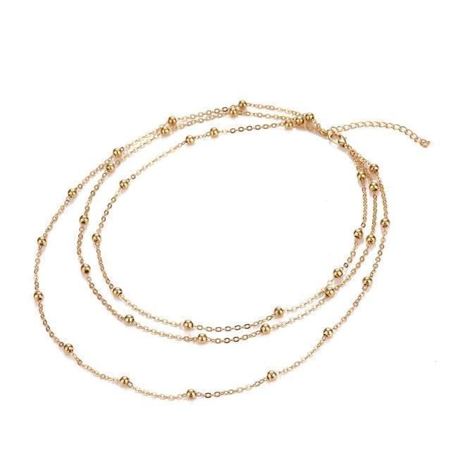 Set of three gold necklaces on a white background