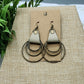 Pair of earrings on a brown card with a natural background
