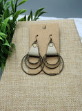 Pair of earrings on a brown card with a natural background