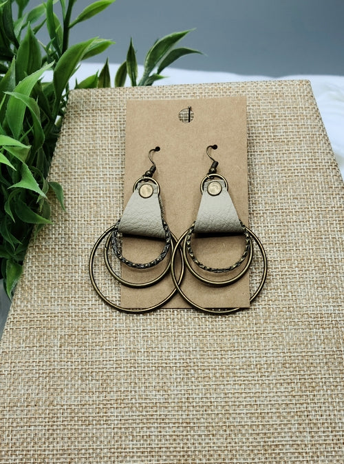 Pair of earrings on a brown card with a natural background