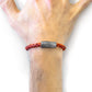 Bracelet with braided design and metal tag on wrist against a white background