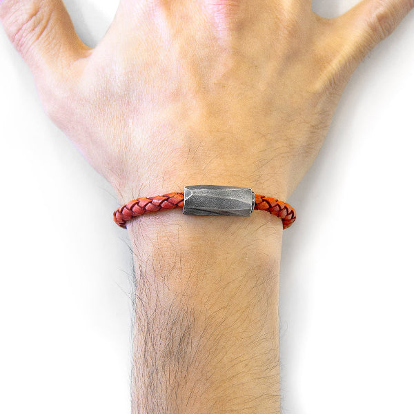 Bracelet with braided design and metal tag on wrist against a white background