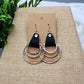 Pair of earrings on a brown card with a natural background