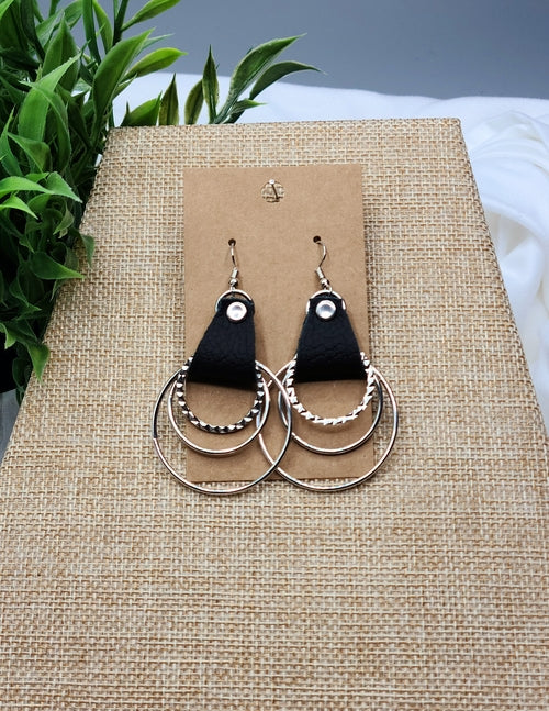 Pair of earrings on a brown card with a natural background