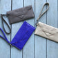 Four handbags in gray, blue, and beige on a wooden surface