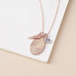 Rose gold fingerprint pendant necklace with a blue gemstone on a beige surface