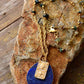 Gold necklace with a blue pendant on a stone surface