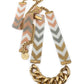 Necklace with gold chain and chevron-patterned arm bands on a white background