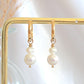 Pearl earrings on a gold stand with a soft background