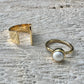 Two gold rings on a textured surface
