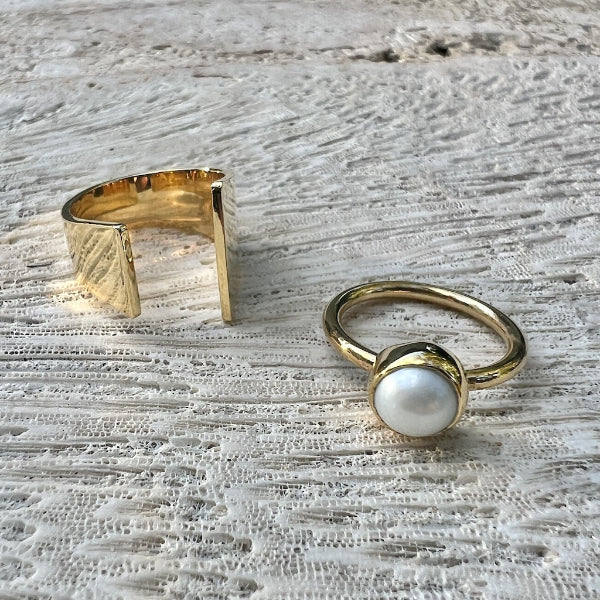 Two gold rings on a textured surface